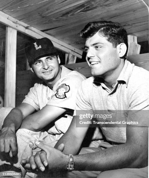American baseball player Charlie Maxwell , of the Louisville Colonels, speaks with pitching prospect Frank Baumann in the dugout, Louisville,...