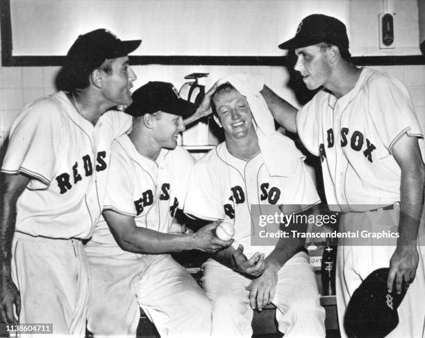 Portrait of four members of the Boston Red Sox baseball team celebrate a victory in the locker room at Fenway Park, Boston, Massachusetts, during the...