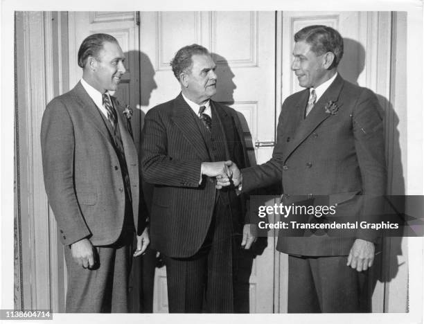 From left, American baseball player Rube Walberg watches as Temple University football coach Pop Warner shakes hands with former baseball player...
