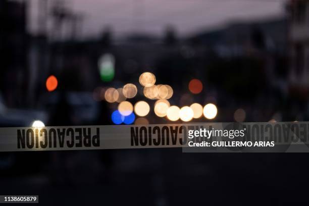 Police tape marks the perimeter of a crime scene where a man was killed by gun fire in downtown Tijuana, Baja California state, Mexico, on April 21,...