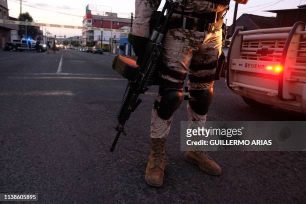 Mexican Soldiers guard a crime scene where a man was killed by gun fire in downtown Tijuana, Baja California state, Mexico, on April 21, 2019. -...