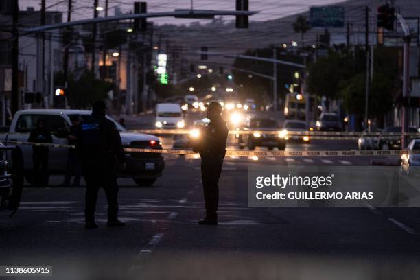 Police officers guard a crime scene where a man was killed by gun fire in downtown Tijuana, Baja California state, Mexico, on April 21, 2019. -...