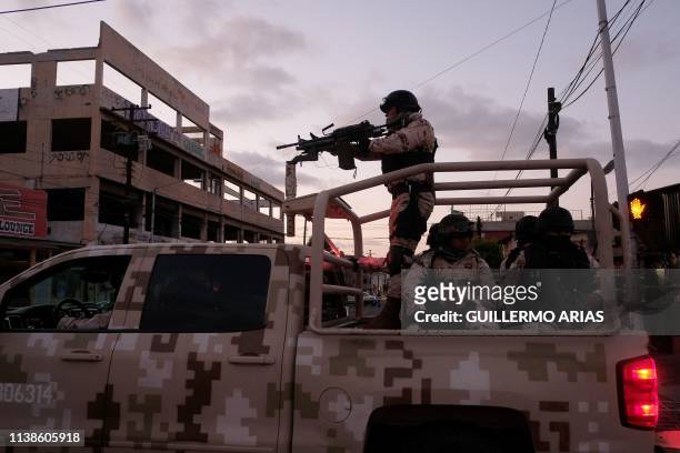 Mexican Soldiers leave the scene of a crime where a man was killed by gun fire in downtown Tijuana, Baja California state, Mexico, on April 21, 2019....