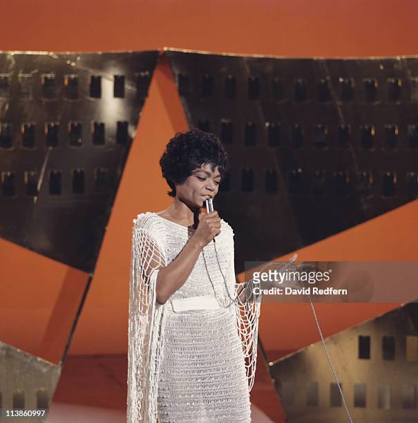 Eartha Kitt , U.S. Singer and actress, singing into a microphone during a live concert performance, circa 1970.