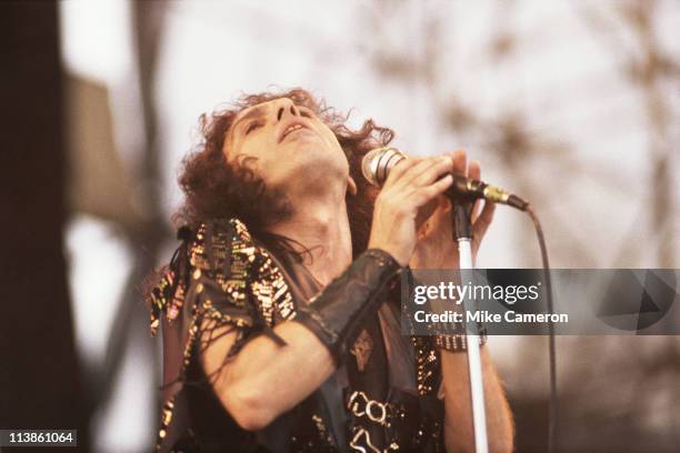 Ronnie James Dio , U.S. Heavy metal singer-songwriter, throwing his head back while holding a microphone, during a live concert performance with his...