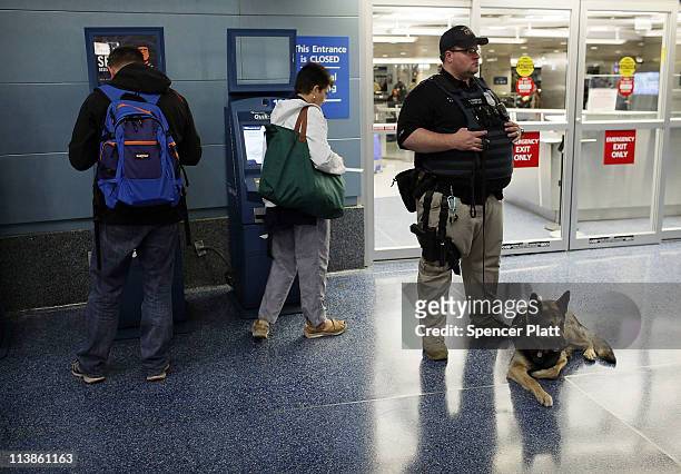 An Amtrak police officer stands guard with a K9 as Transportation Secretary Ray LaHood speaks to the media regarding national high-speed rail service...