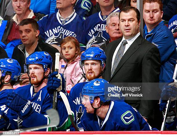 Head coach Alain Vigneault, Daniel Sedin, Henrik Sedin and Mason Raymond of the Vancouver Canucks look on from the bench in Game Five of the Western...