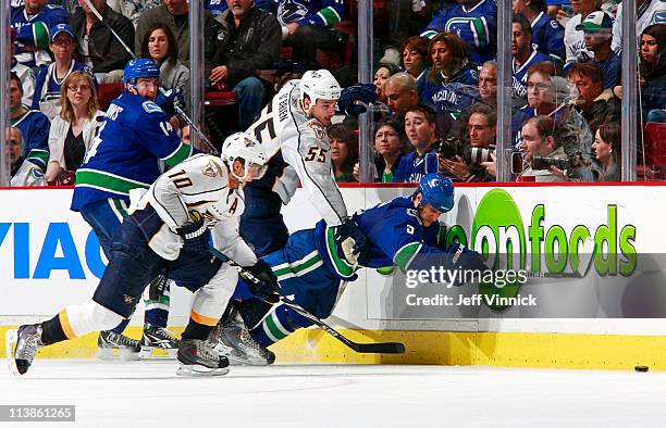 Martin Erat of the Nashville Predators and Alex Burrows of the Vancouver Canucks look on as Shane O'Brien of the Nashville Predators trips up Kevin...