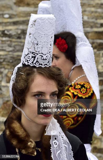 Young women wearing traditional costumes and Coiffe Bigoudene , Festival of Blue Nets, Concarneau, Brittany, France.