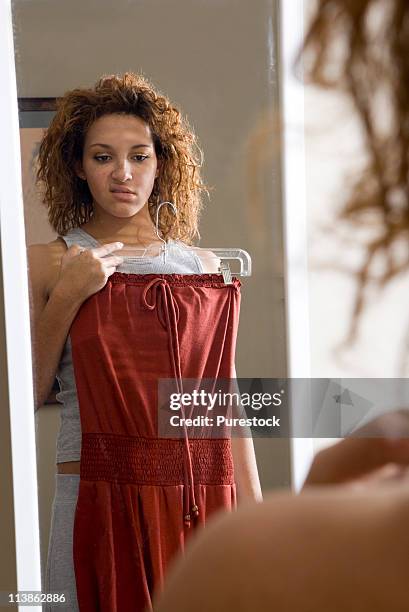 young woman frowning in mirror, getting dressed - woman full length mirror stock pictures, royalty-free photos & images