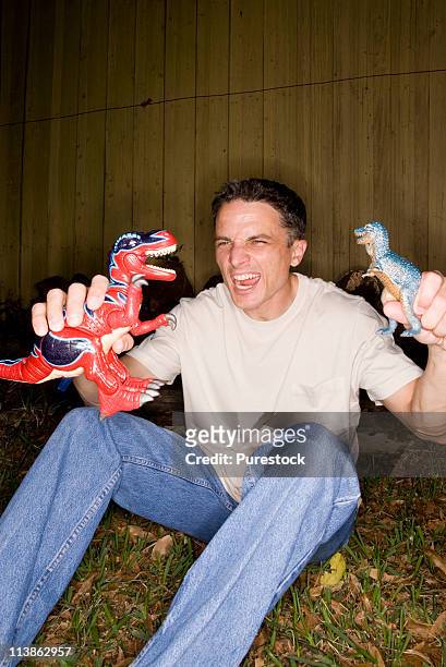 man playing with toy dinosaurs - dinosaur toy i - fotografias e filmes do acervo