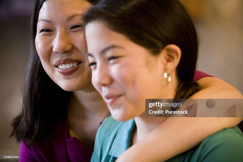Close-up portrait of an mother embracing her daughter in the kitchen