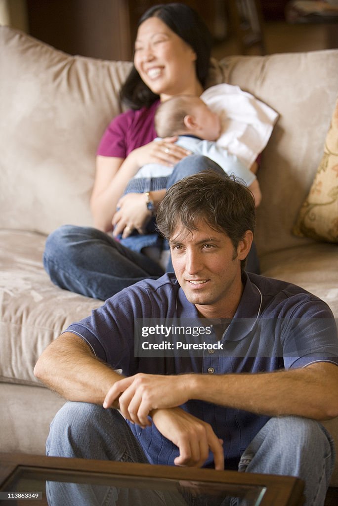 Portrait of an Family sitting on sofa and the floor