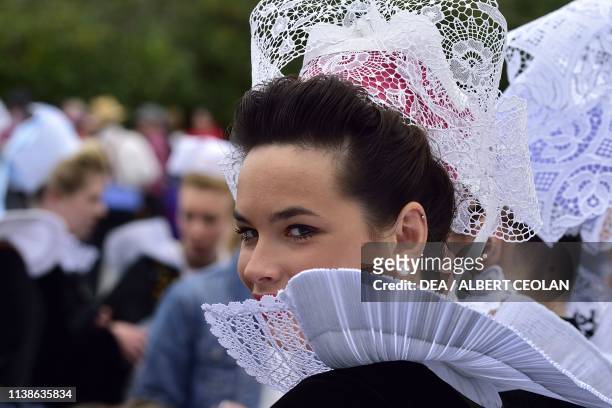 Woman wearing a traditional costume adorned with lace, Festival of Blue Nets, Concarneau, Brittany, France.