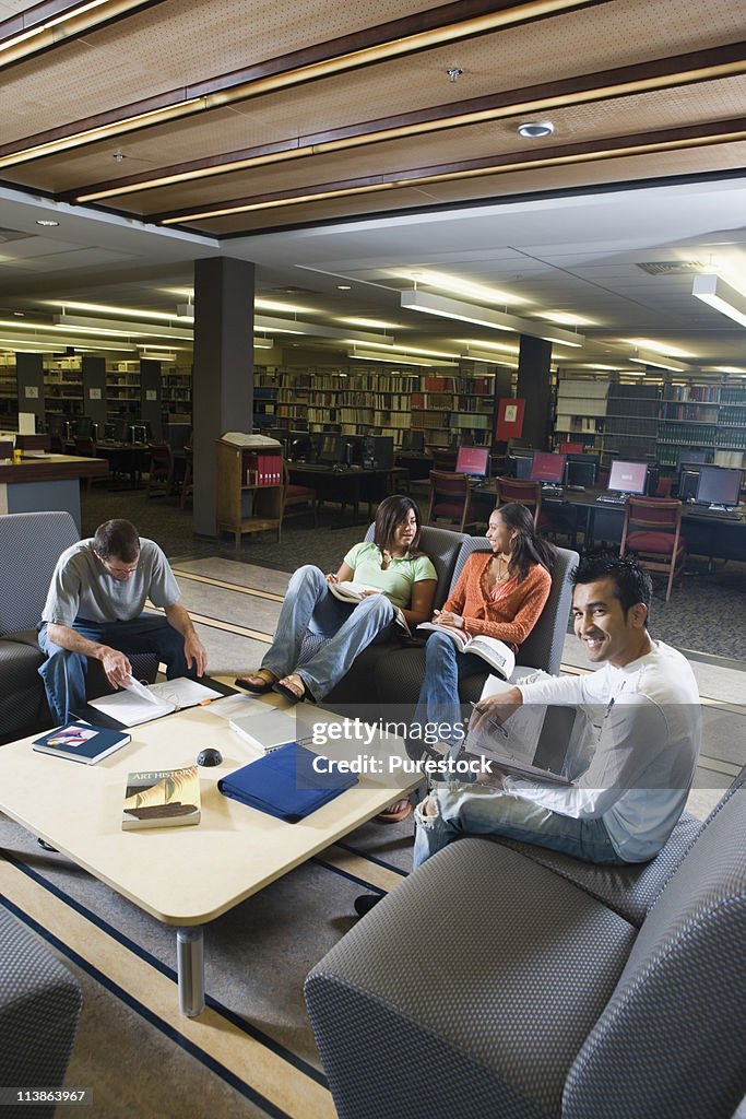 Students in library sitting on sofas studying