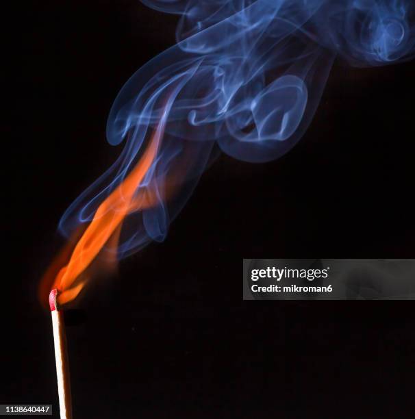 extinguished matchstick smoke on black background - matchstick stock pictures, royalty-free photos & images