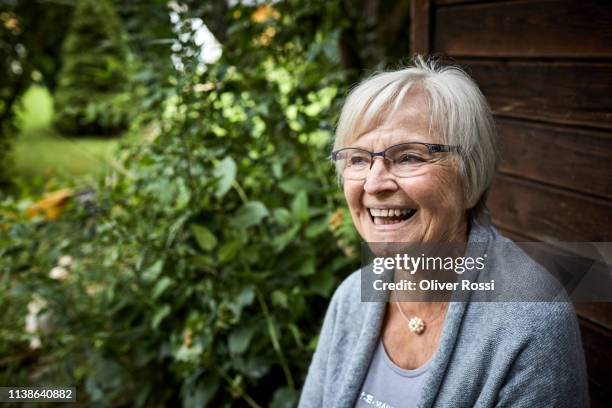 happy senior woman at garden shed - happy old women stockfoto's en -beelden