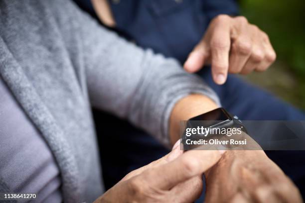 close-up of senior women using smart watch - wrist stock pictures, royalty-free photos & images