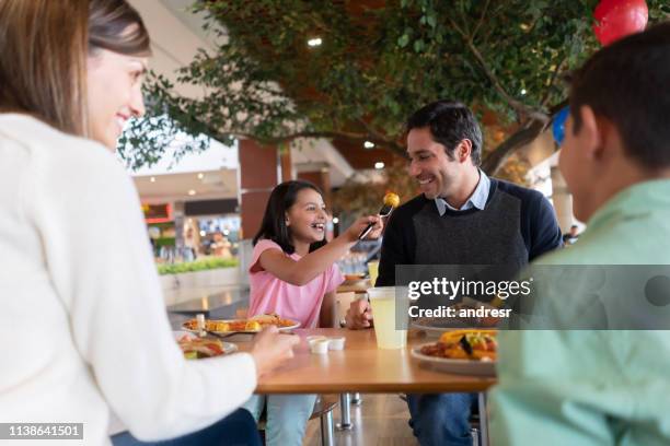 gelukkig meisje eten luch met haar familie en het delen met haar vader - family mall stockfoto's en -beelden