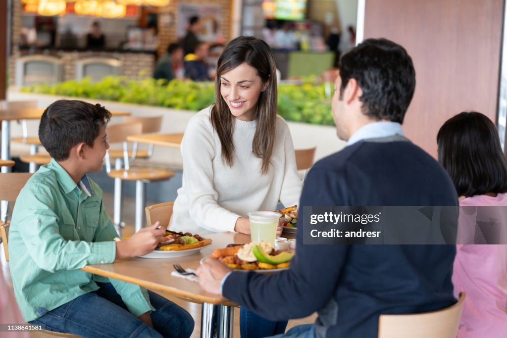 Fröhliches Familienessen auf dem Essensstand im Einkaufszentrum