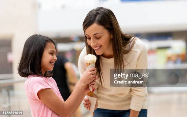 mother and daughter shopping and eating an ice cream at the mall - family mall stock pictures, royalty-free photos & images