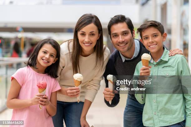 happy family eating an ice cream at the shopping center - ice cream family stock pictures, royalty-free photos & images