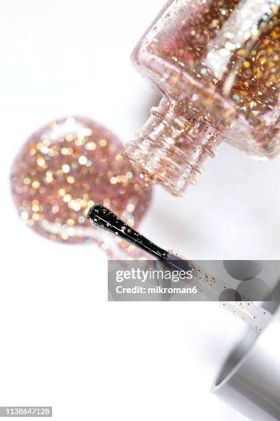 nail varnish spilling onto white background. - gold nail polish stock-fotos und bilder