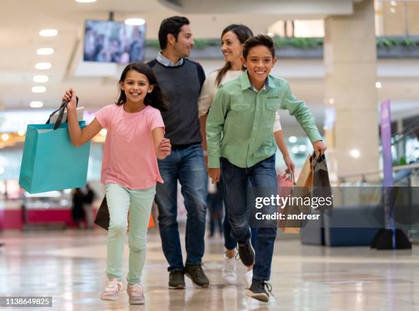 happy family shopping and running at the mall - family mall stock pictures, royalty-free photos & images