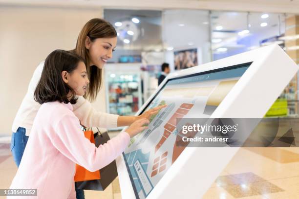 madre e hija de compras en el centro comercial y encontrar una tienda en un mapa - mapa localizador fotografías e imágenes de stock