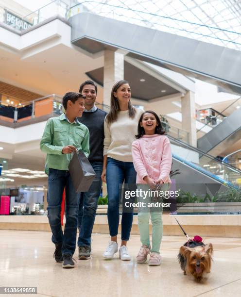 felice shopping in famiglia in un centro commerciale pet friendly con il loro cane - shopping mall foto e immagini stock