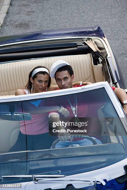 portrait of a young hip-hop couple sitting in a pimped-up vintage car - pimped car foto e immagini stock