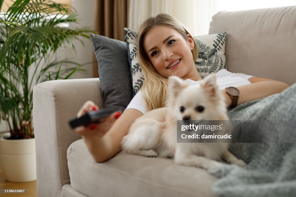 Young woman watching TV at home
