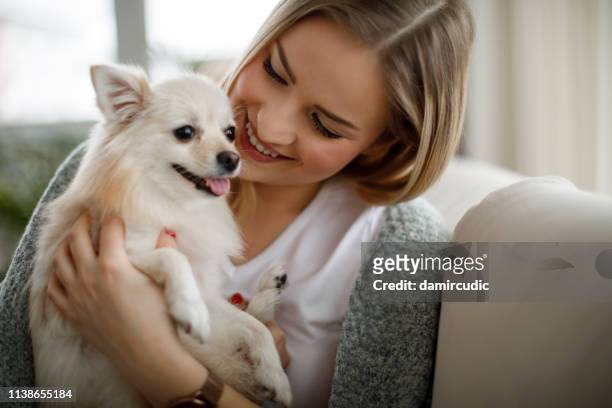 woman cuddling with her dog - home sweet home dog stock pictures, royalty-free photos & images