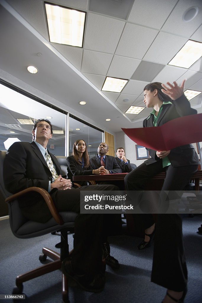 Low angle view of business men and women at a presentation in a formal conference room