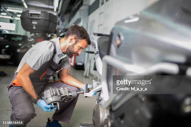 at motorcycle servicess - motorcycle mechanic stock pictures, royalty-free photos & images