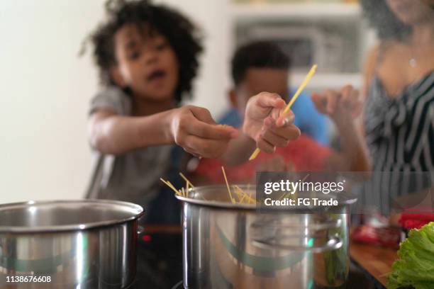 familie kochen zusammen in der küche - black mother and child cooking stock-fotos und bilder