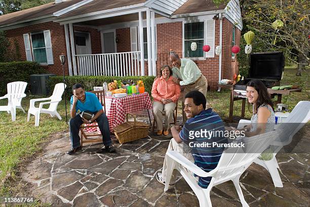 family enjoying back yard barbecue - family back yard stockfoto's en -beelden