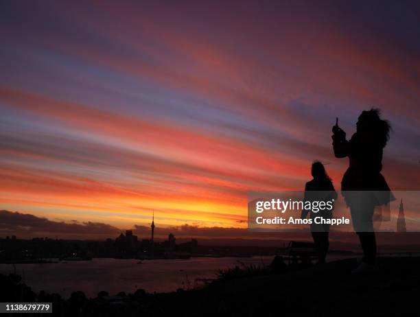 women take photos at sunset. - amos chapple stock pictures, royalty-free photos & images
