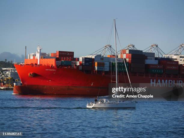 a container ship leaves auckland harbour. - amos chapple stock pictures, royalty-free photos & images