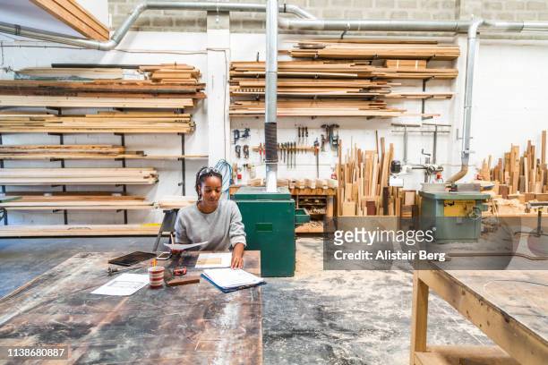 young black female designer working in a woodworking workshop - black business owner ストックフォトと画像
