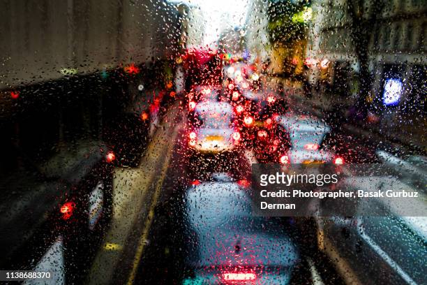 defocused photograph of rush hour traffic on busy highway on a rainy evening - caught in rain stock pictures, royalty-free photos & images