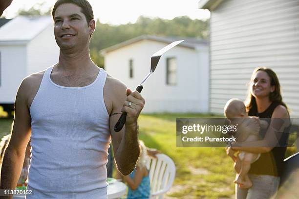 family cookout in backyard - couple grilling stock pictures, royalty-free photos & images