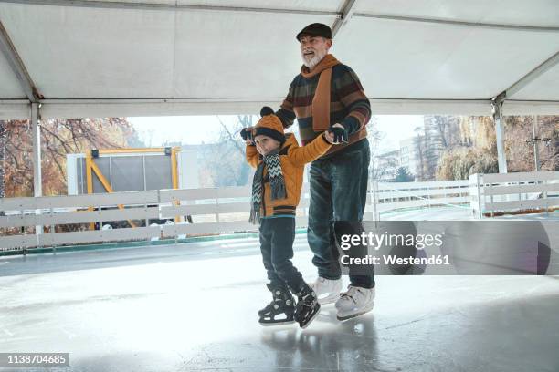 grandfather and grandson on the ice rink, ice skating - ice rink stock pictures, royalty-free photos & images