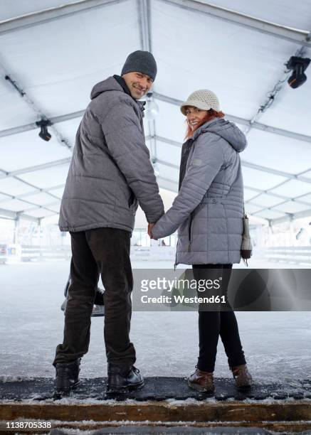 couple standing at the ice rink - indoor skating stock pictures, royalty-free photos & images