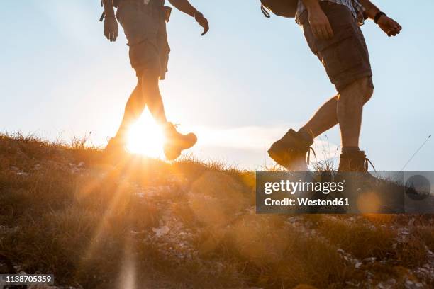 italy, monte nerone, close-up of two men hiking in mountains at sunset - downhill skiing stock pictures, royalty-free photos & images