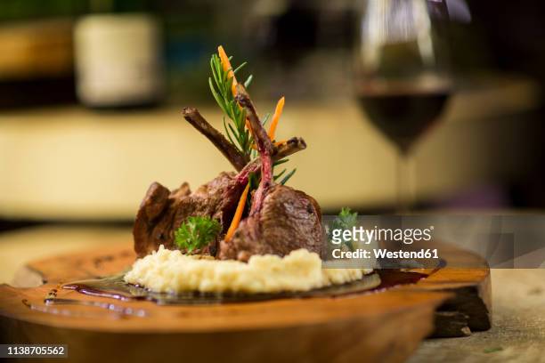 garnished lamb chop on wooden serving plate - lamb stock-fotos und bilder