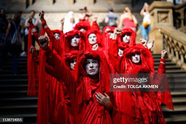 Extinction Rebellion climate change activists in red costume attend a mass "die in" in the main hall of the Natural History Museum in London on April...