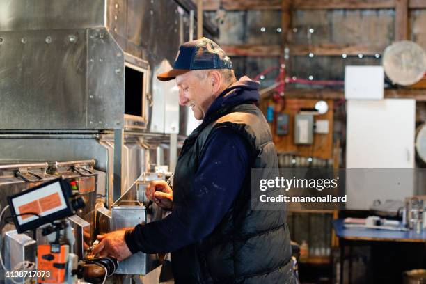 senior men working at sugar shack for maple syrup family industry - sugar shack stock pictures, royalty-free photos & images