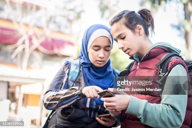 Teenage tourists using smartphone for searching location in city