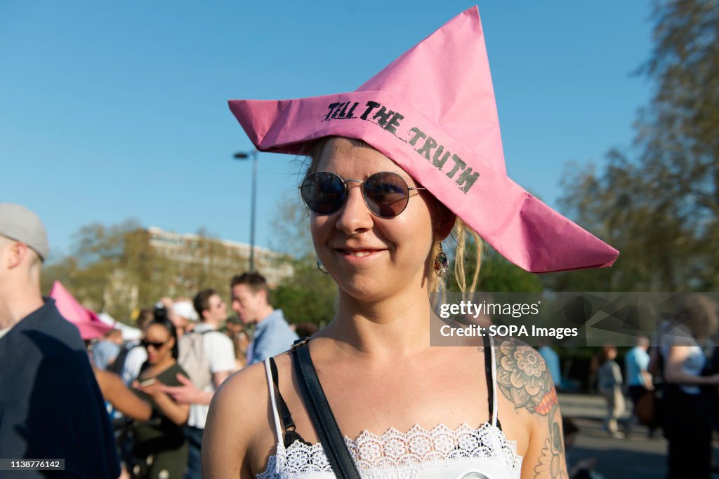 An activist is seen wearing a pink paper hat emulating the...